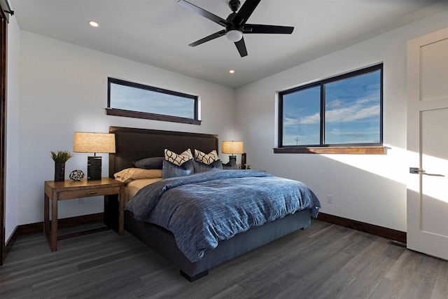 bedroom with multiple windows, wood finished floors, and baseboards