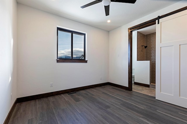 empty room featuring a barn door, baseboards, dark wood-style floors, ceiling fan, and recessed lighting