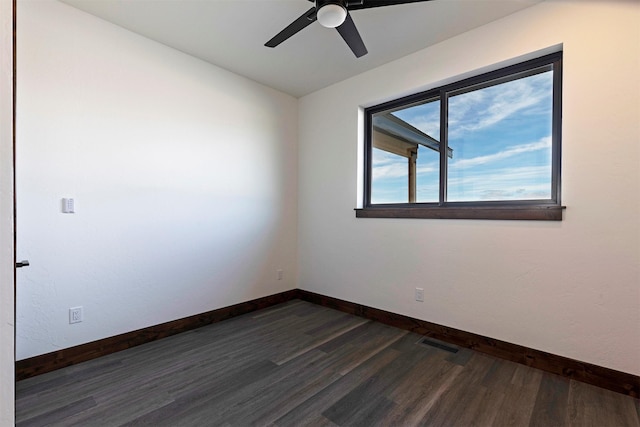 empty room featuring a ceiling fan, dark wood-style flooring, visible vents, and baseboards