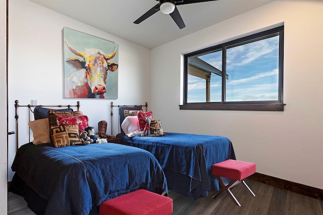 bedroom featuring wood finished floors, a ceiling fan, and baseboards