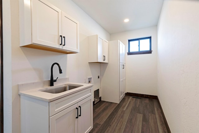 laundry area with cabinet space, dark wood-style floors, hookup for a washing machine, hookup for an electric dryer, and a sink