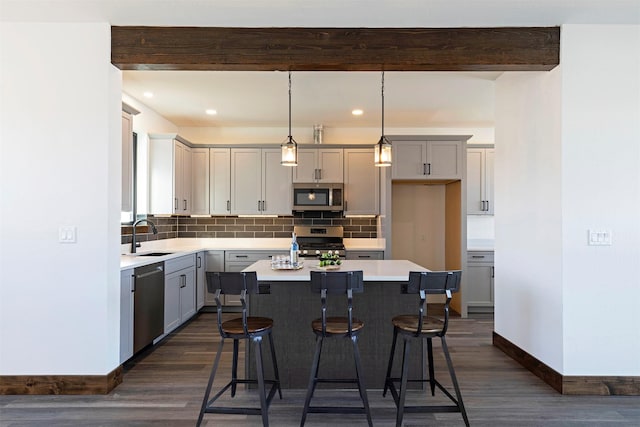 kitchen with decorative backsplash, stainless steel appliances, a sink, and beamed ceiling