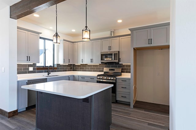 kitchen featuring stainless steel appliances, dark wood-type flooring, a sink, and gray cabinetry