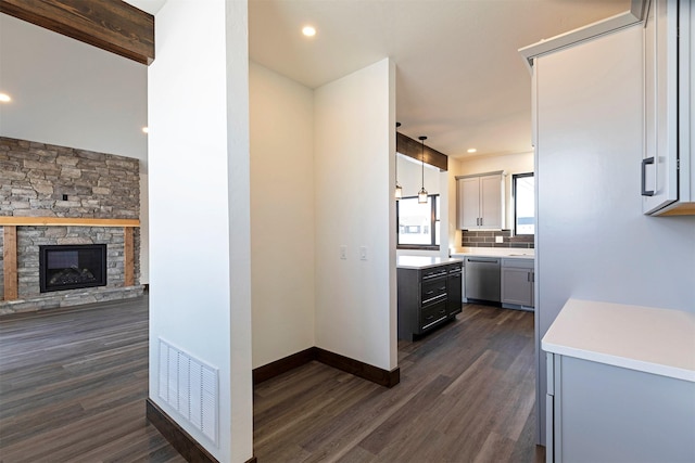 kitchen with visible vents, dark wood-style flooring, stainless steel dishwasher, and light countertops