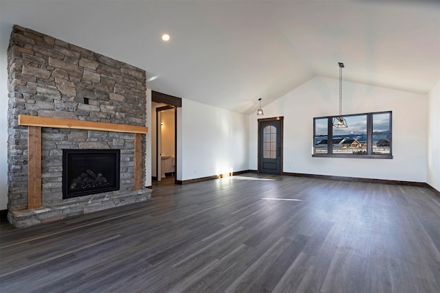 unfurnished living room with baseboards, vaulted ceiling, dark wood-type flooring, and a stone fireplace