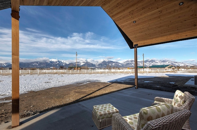 view of patio / terrace featuring fence and a mountain view