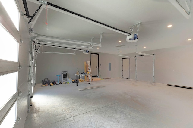 garage featuring recessed lighting, electric panel, and a garage door opener