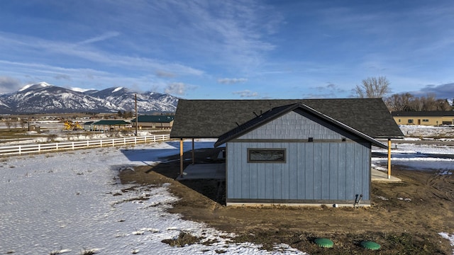 view of outbuilding featuring fence and a mountain view