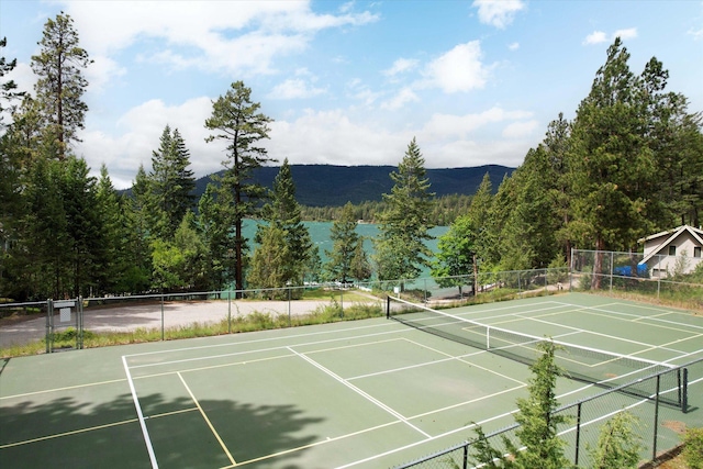 view of sport court with fence and a mountain view