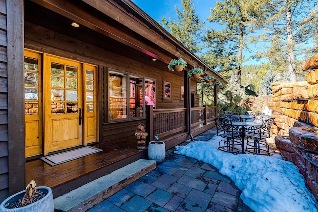 property entrance featuring outdoor dining area and a patio