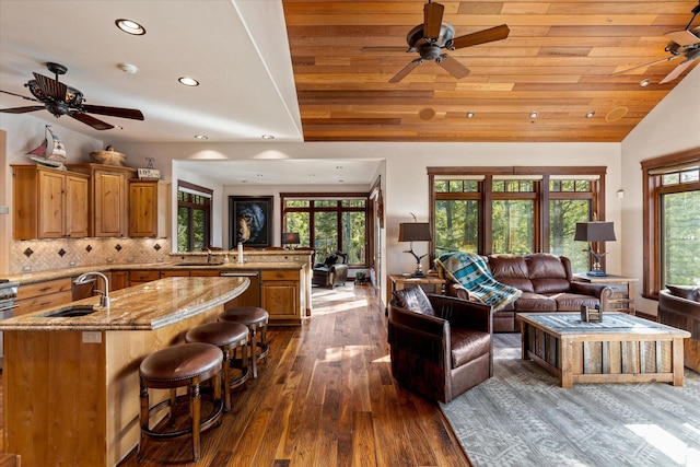 living room with dark wood-style floors, plenty of natural light, vaulted ceiling, and recessed lighting