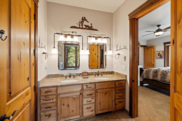 ensuite bathroom with ceiling fan, double vanity, a sink, and connected bathroom