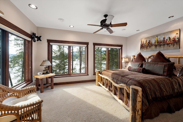 carpeted bedroom featuring recessed lighting, multiple windows, ceiling fan, and baseboards