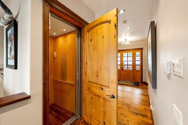 hallway with recessed lighting, visible vents, and wood finished floors