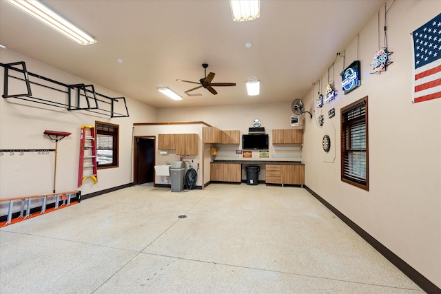 garage featuring a ceiling fan and baseboards