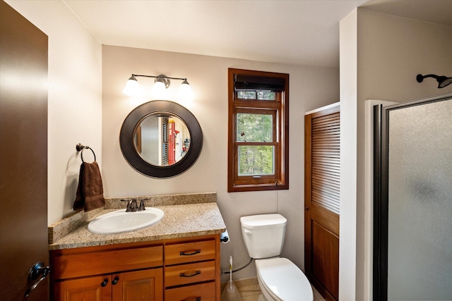 bathroom featuring vanity, toilet, and a shower stall