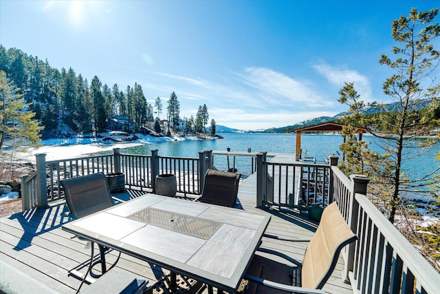 wooden deck featuring outdoor dining area and a water view