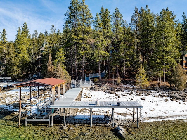 view of dock with a forest view and boat lift