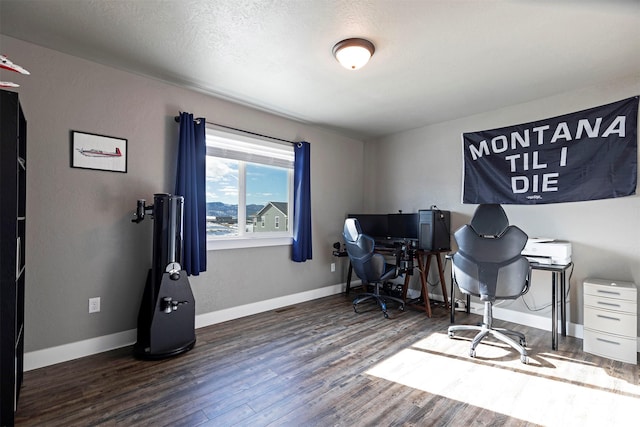 office area with a textured ceiling, baseboards, and wood finished floors