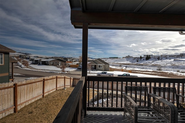 snow covered deck with a fenced backyard and a residential view