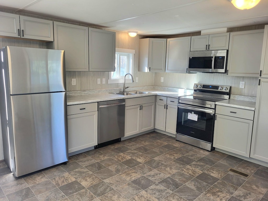 kitchen with a sink, light countertops, visible vents, and stainless steel appliances