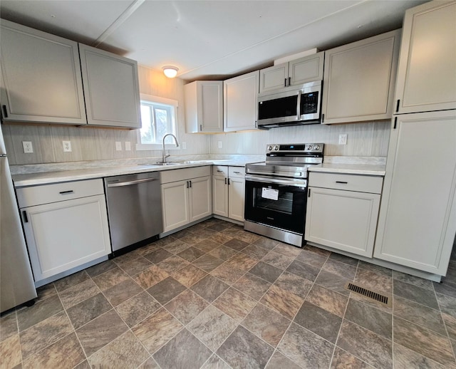 kitchen featuring a sink, light countertops, visible vents, and stainless steel appliances