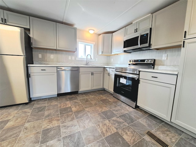 kitchen with visible vents, appliances with stainless steel finishes, light countertops, and a sink