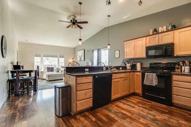 kitchen with dark countertops, black appliances, light brown cabinets, and a peninsula