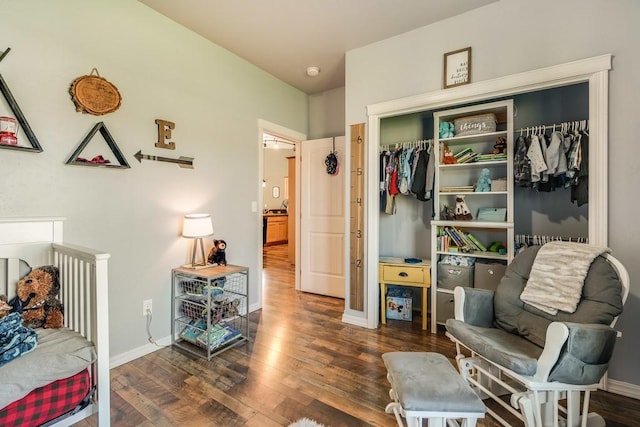 bedroom with dark wood-style flooring, a closet, and baseboards