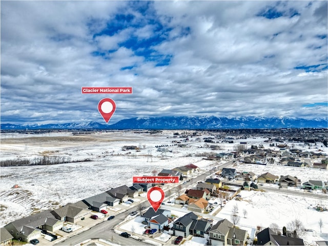 snowy aerial view featuring a residential view and a mountain view