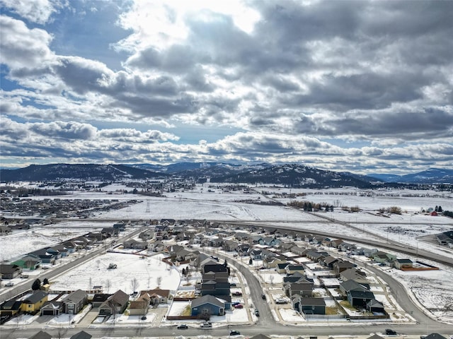 snowy aerial view with a residential view and a mountain view