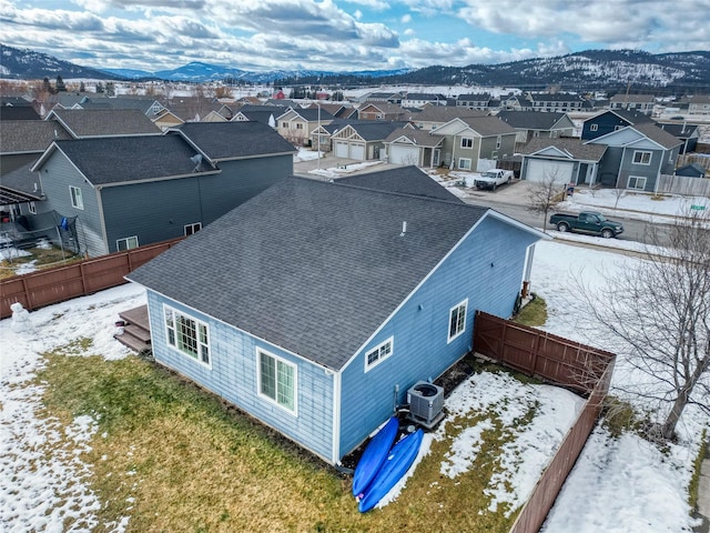 snowy aerial view with a residential view and a mountain view