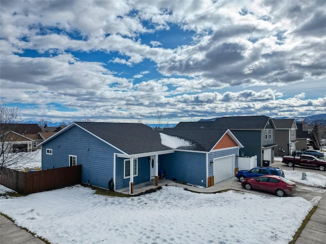 ranch-style house featuring a garage, a residential view, and fence