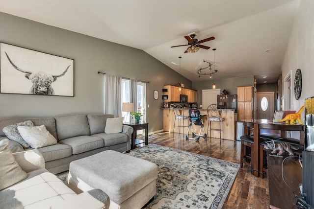 living room featuring dark wood-type flooring, vaulted ceiling, and a ceiling fan