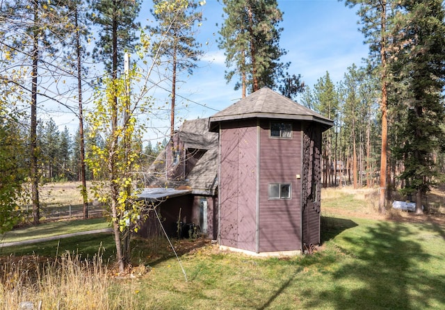 view of side of home featuring a yard and a shingled roof