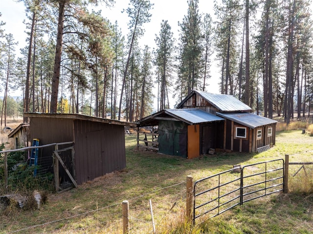 view of outdoor structure featuring fence and an outdoor structure