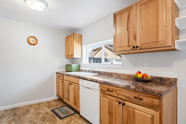 kitchen with dishwasher, dark countertops, a sink, and baseboards