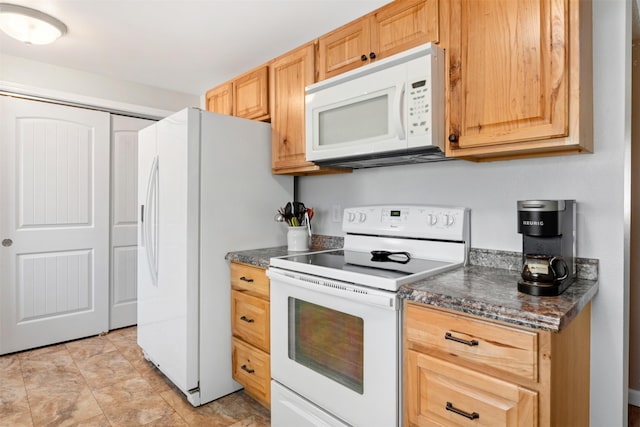 kitchen with white appliances and dark countertops