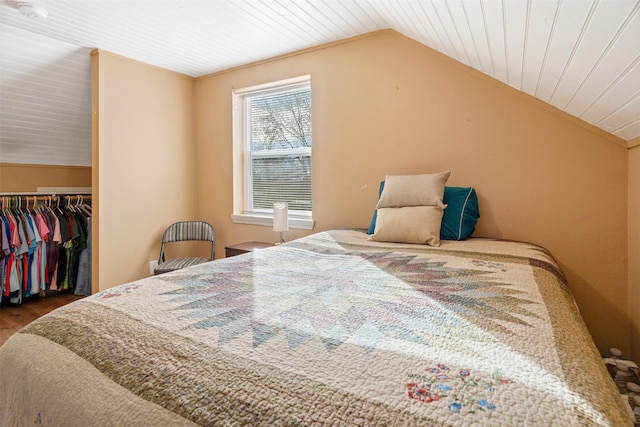 bedroom with a closet, wooden ceiling, vaulted ceiling, and wood finished floors