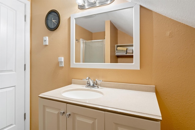 bathroom with a shower stall and vanity