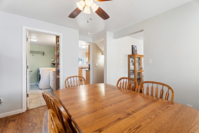 dining area featuring a ceiling fan, washer / clothes dryer, and wood finished floors