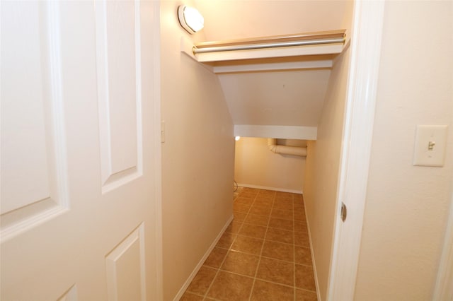 hallway featuring baseboards and tile patterned floors