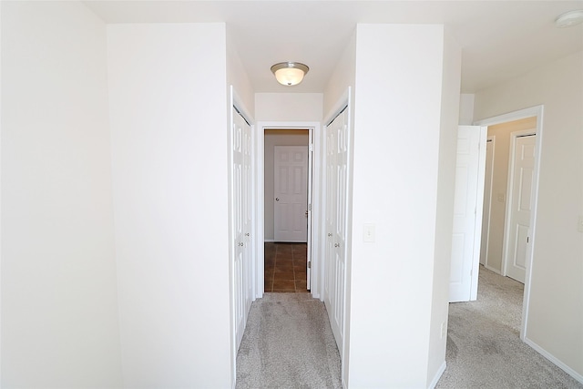 corridor with light carpet and baseboards