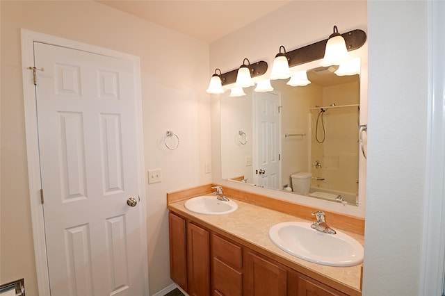 bathroom with toilet, double vanity, a sink, and washtub / shower combination