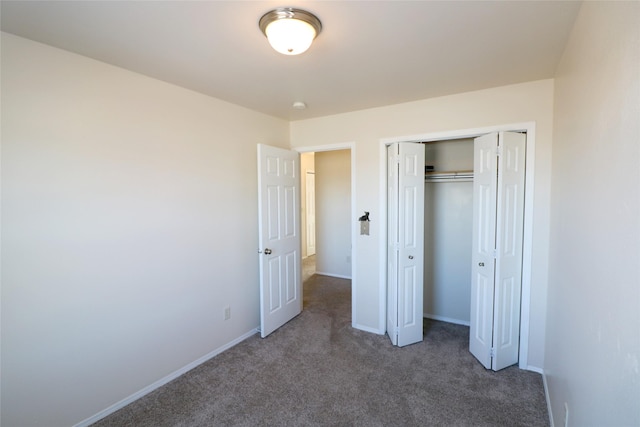 unfurnished bedroom with carpet floors, a closet, and baseboards