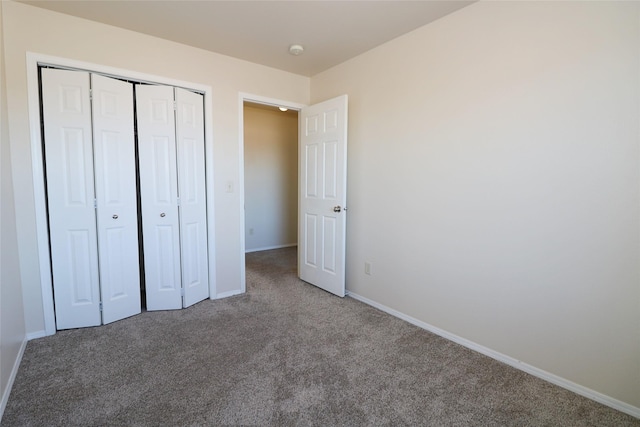 unfurnished bedroom featuring a closet, carpet flooring, and baseboards