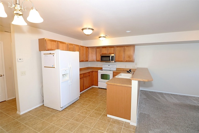 kitchen with a peninsula, white appliances, baseboards, light countertops, and decorative light fixtures