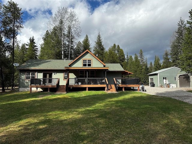 back of house with an outdoor structure, gravel driveway, a deck, and a lawn