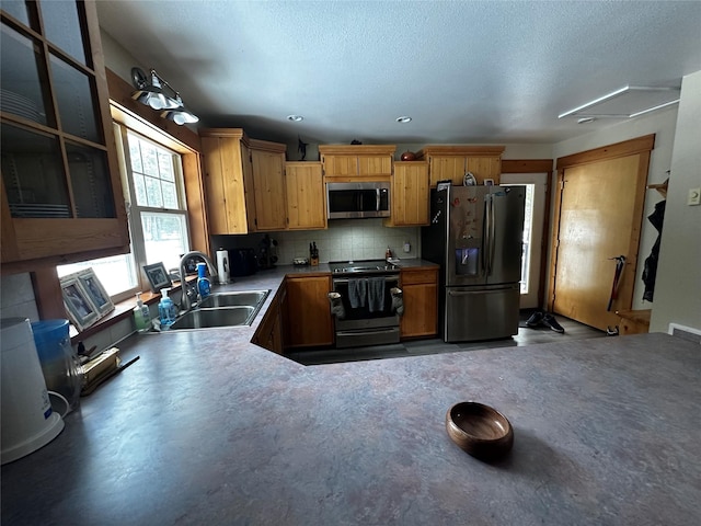 kitchen featuring visible vents, decorative backsplash, appliances with stainless steel finishes, a sink, and a textured ceiling