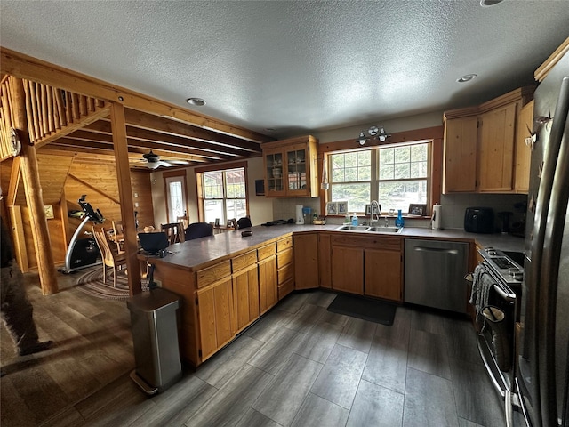 kitchen with dark wood-type flooring, a sink, range with electric cooktop, dishwasher, and a peninsula